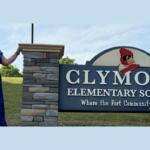 Carrie Barb in front of the Clymore Elementary School sign