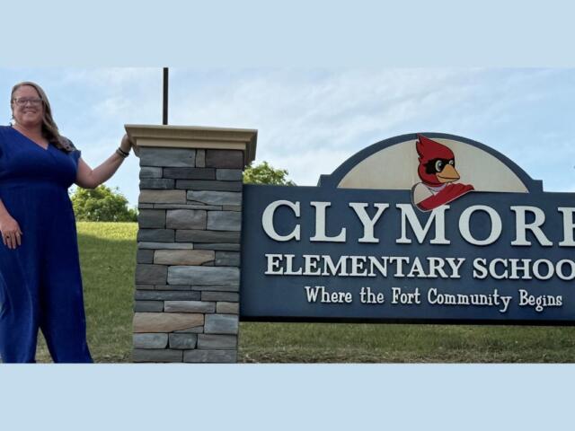 Carrie Barb in front of the Clymore Elementary School sign