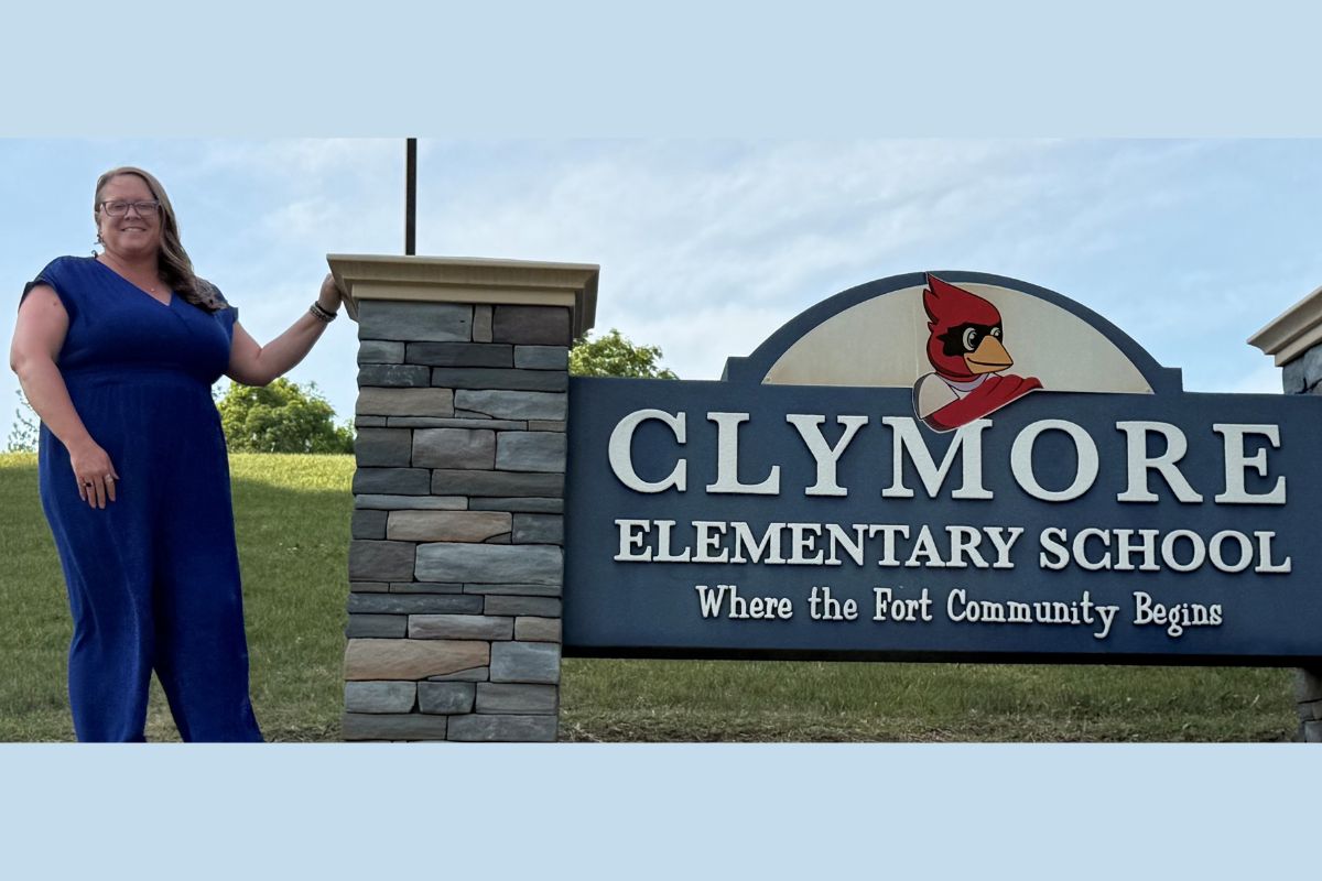 Carrie Barb in front of the Clymore Elementary School sign