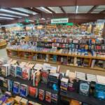 Inside a large bookstore with a central display of stacked science fiction books and a 'Science Fiction' sign overhead.