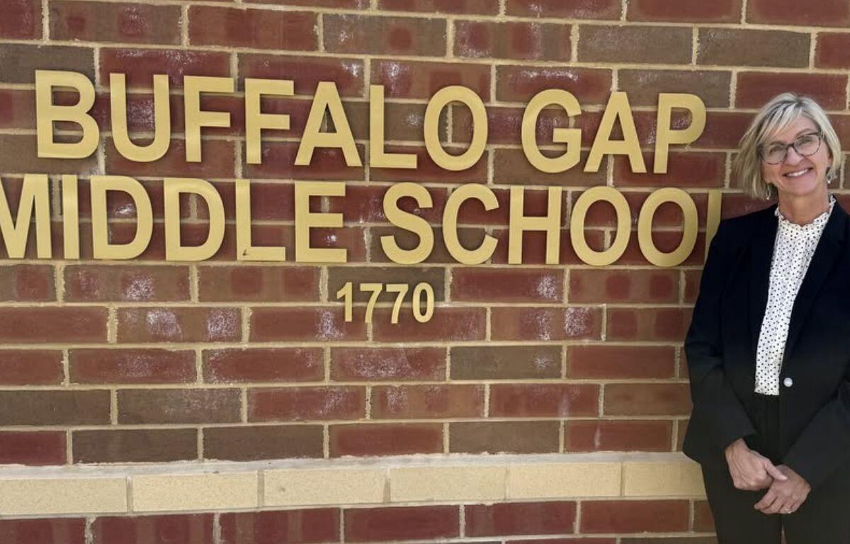 Tammy Chambers standing in front of the logo for Buffalo Gap Middle School