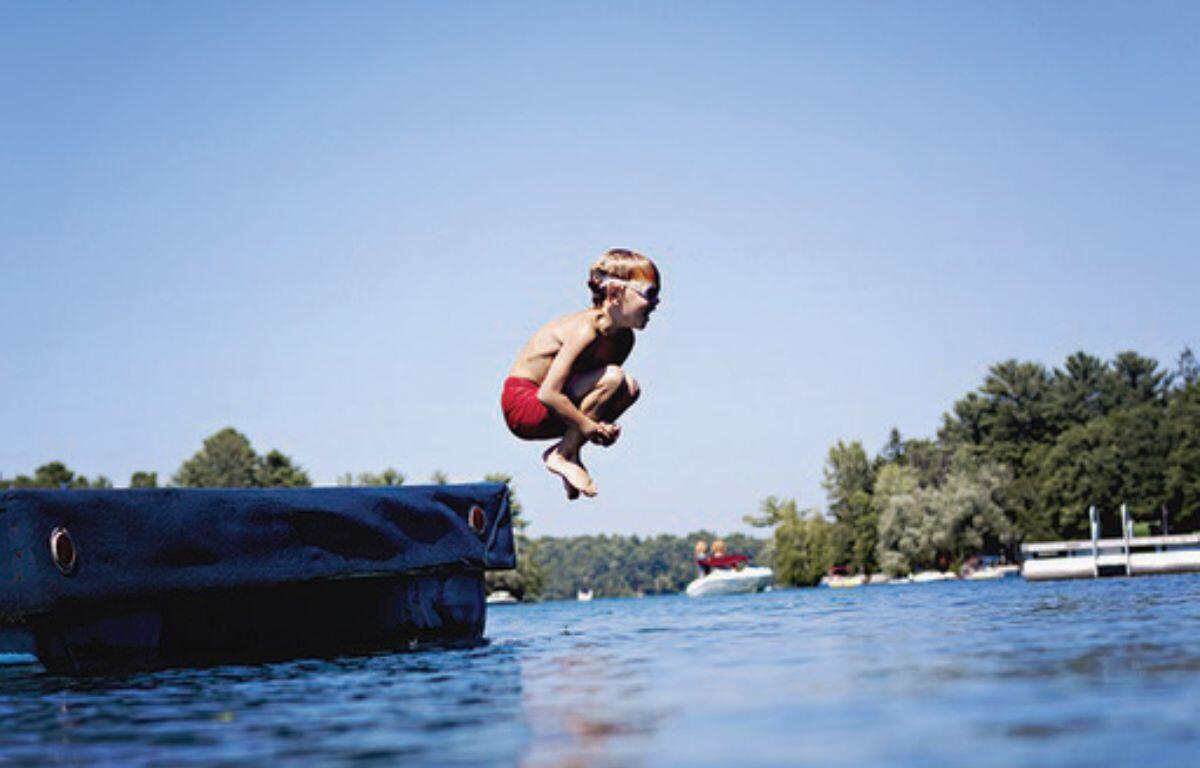 Boy jumping into a lake