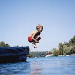 Boy jumping into a lake