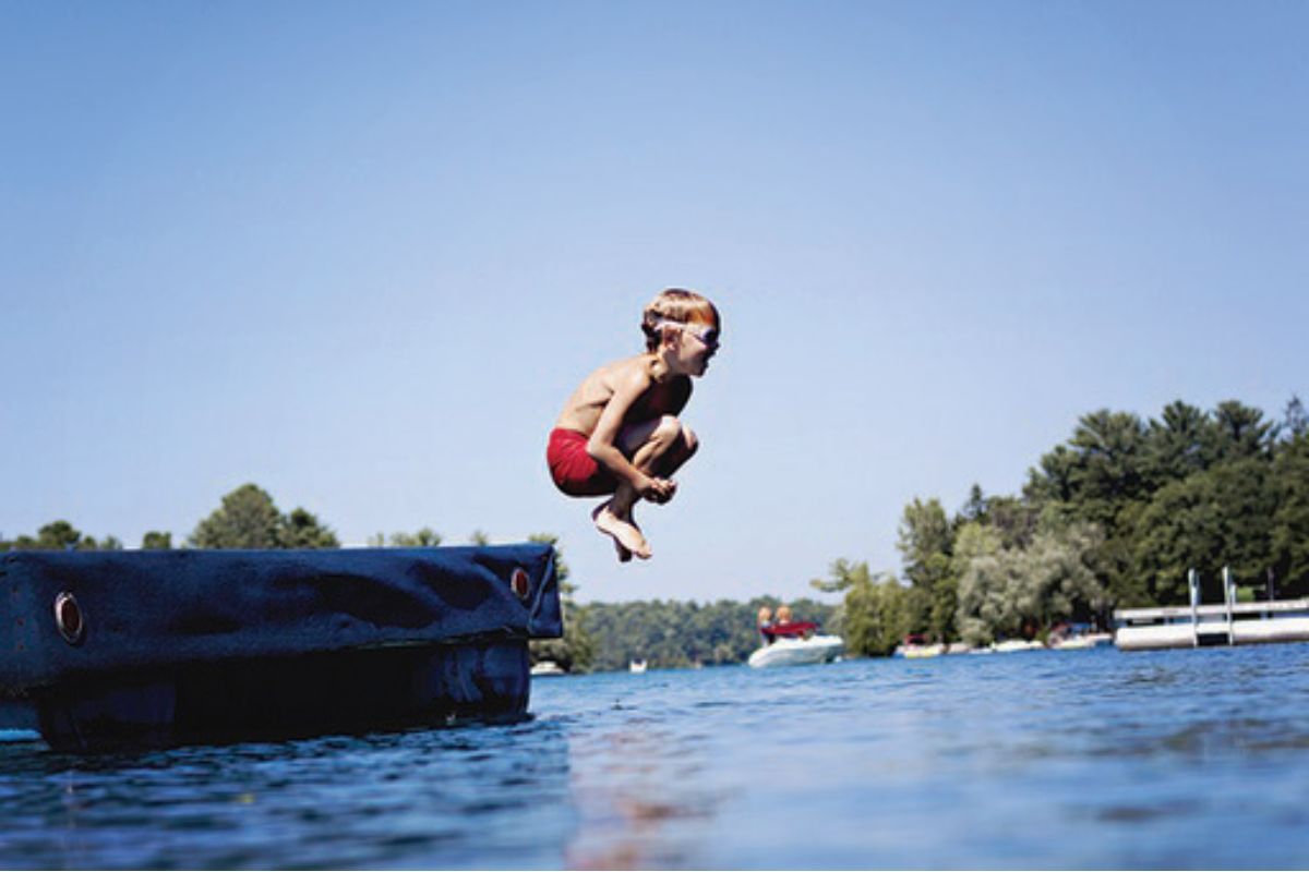 Boy jumping into a lake
