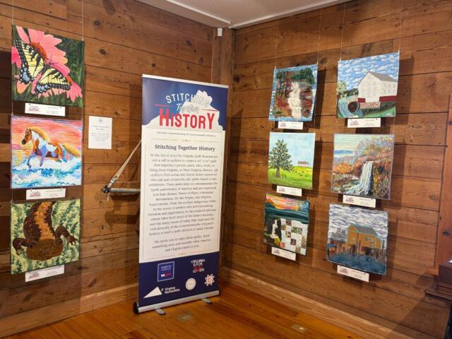 Stitching Together History sign with various quilt designs on the wall