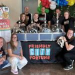 HDR team and raffle volunteers pose with BINGO ball machines after the 2025 Friendly City Fortune drawing.