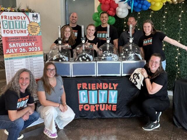HDR team and raffle volunteers pose with BINGO ball machines after the 2025 Friendly City Fortune drawing.