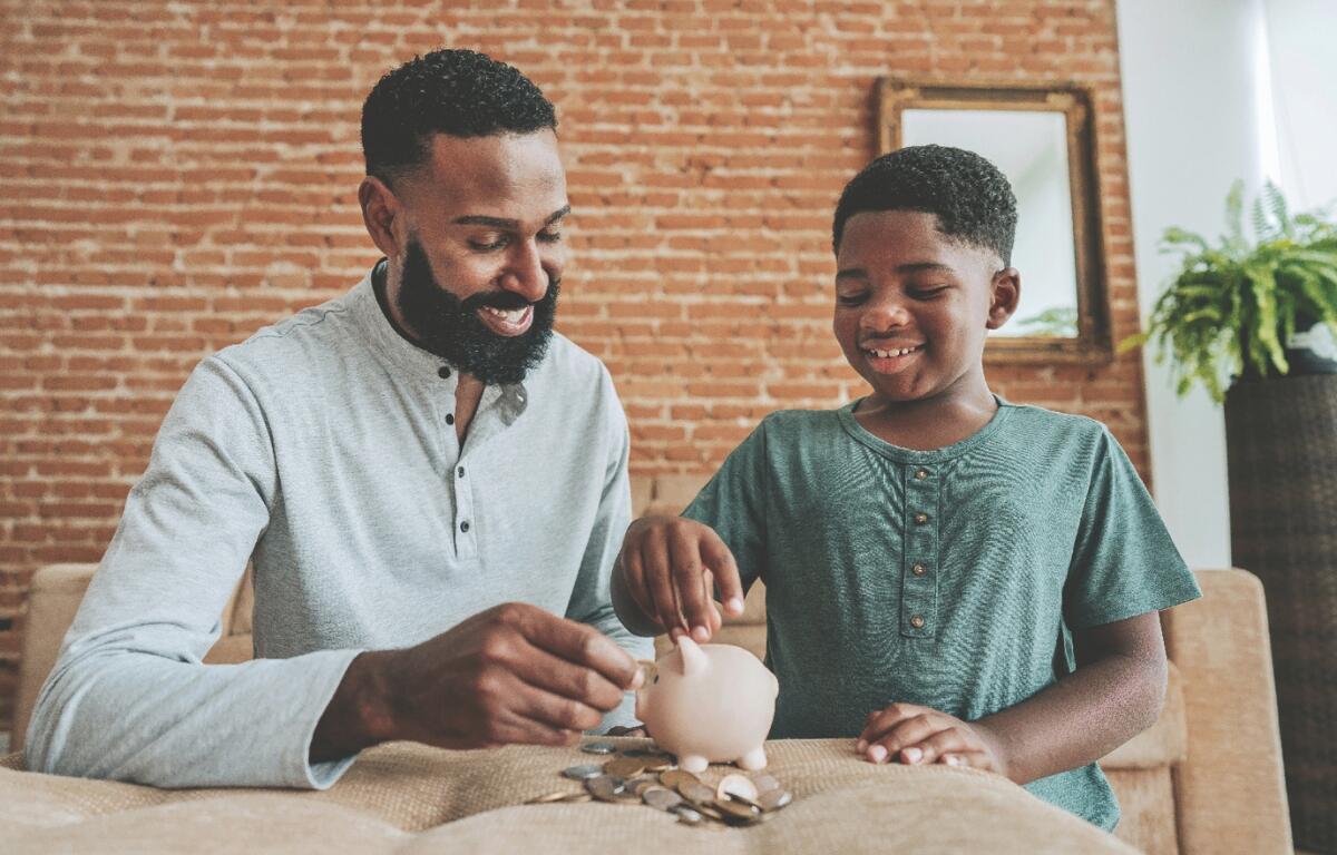 A kid puts money into a piggy bank.
