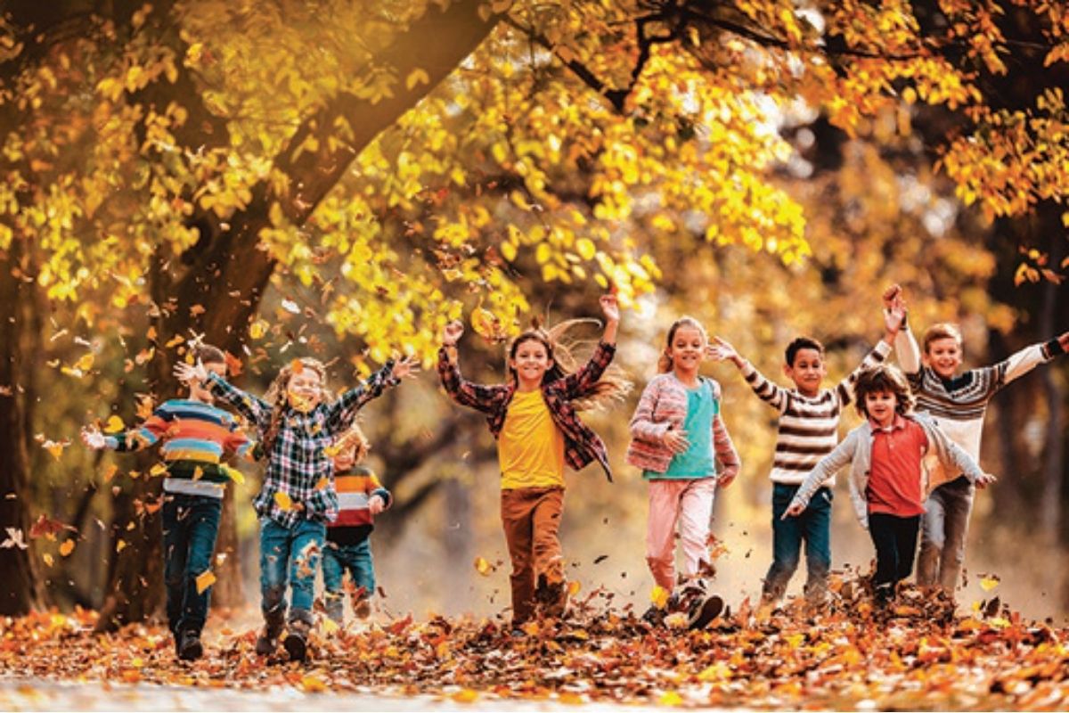Kids playing in the fall leaves