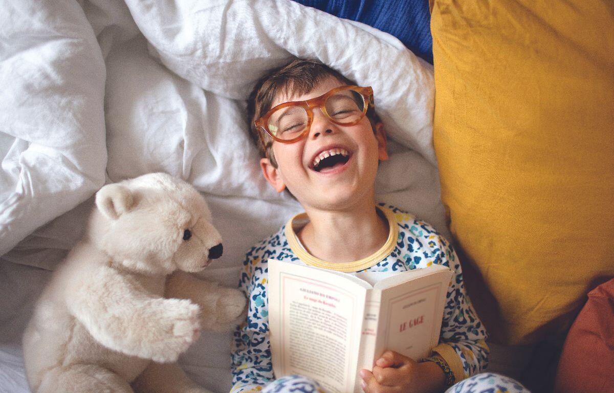 Young boy reading with polar bear stuffed animal
