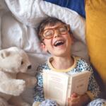 Young boy reading with polar bear stuffed animal