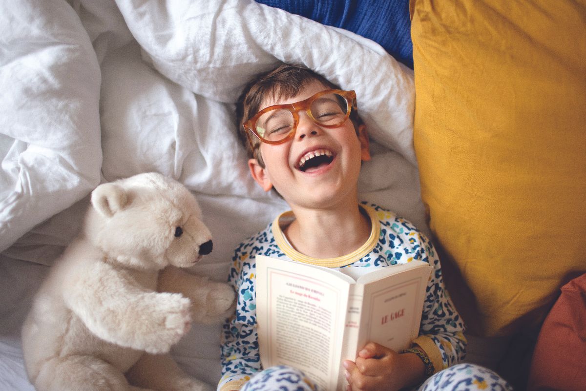 Young boy reading with polar bear stuffed animal