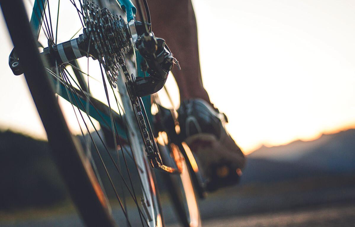 Person pedaling a bicycle from the rear wheel