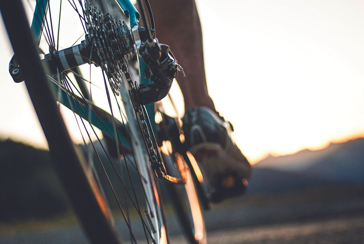 Person pedaling a bicycle from the rear wheel