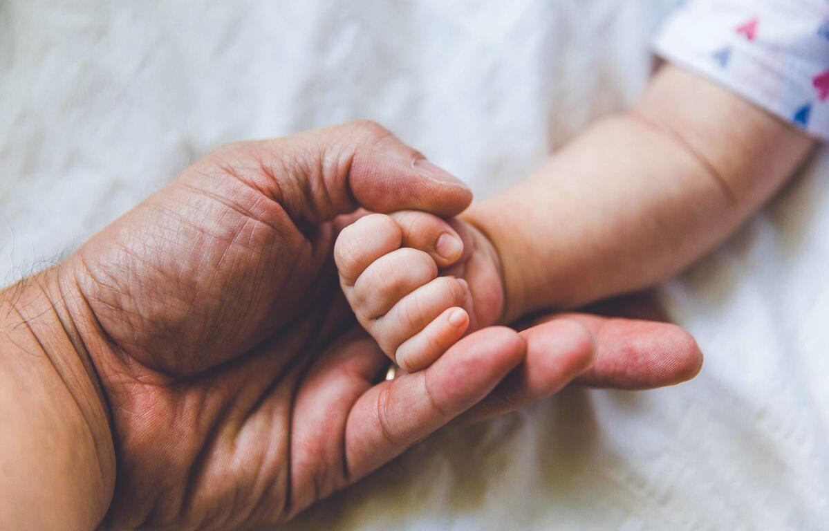 Parent holding baby's hand