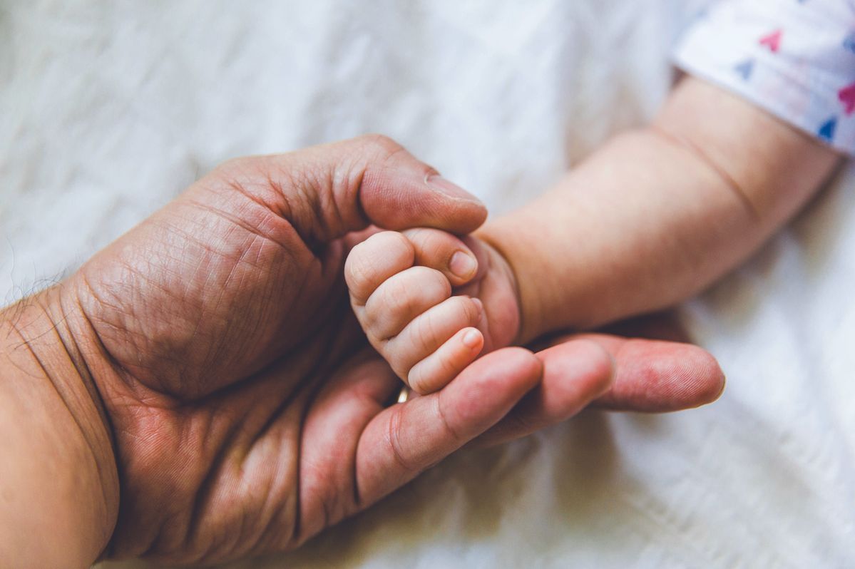 Parent holding baby's hand